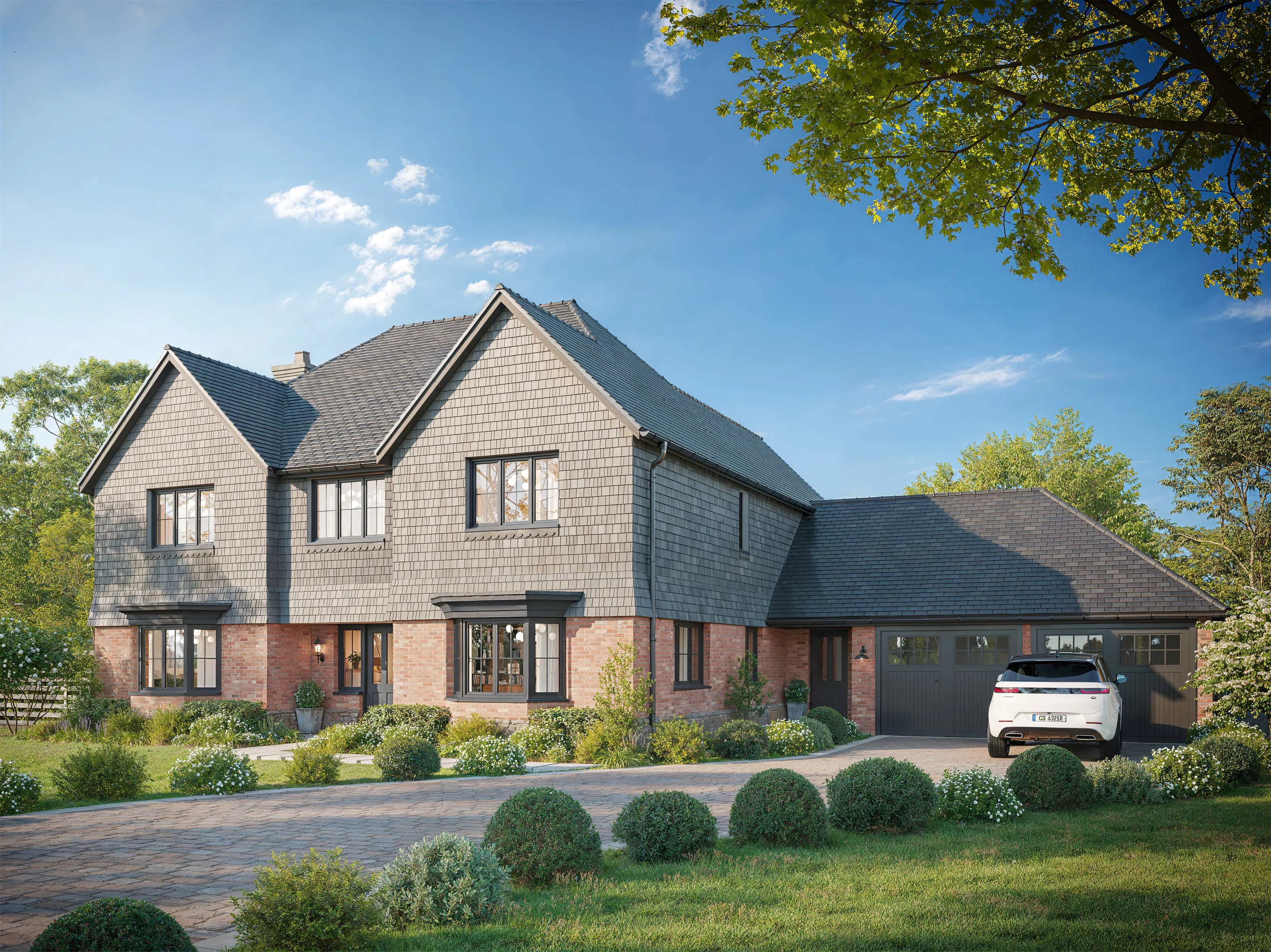 Two-story grey shingle and brick house with garage wing and detailed front landscaping
